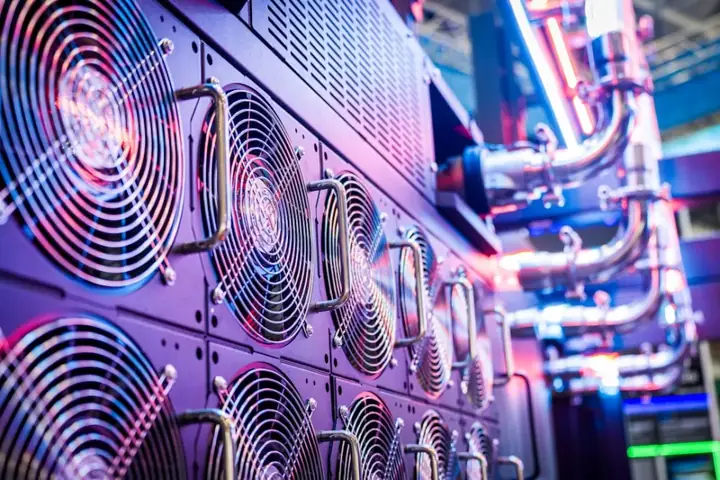 Rows of server cooling fans and pipework under purple light – data management and backup